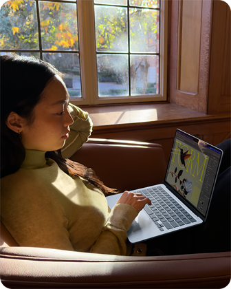 Човек на стол, използващ своя MacBook Air