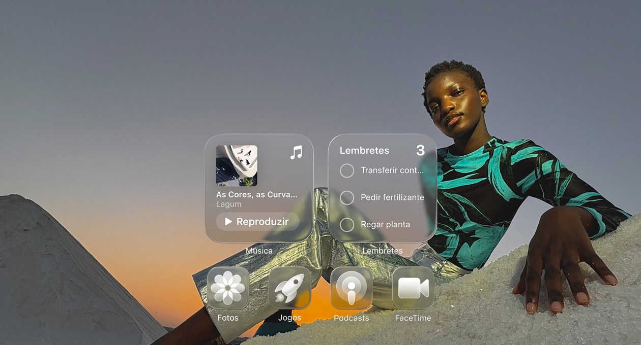 Tela em Liquid Glass com ícones de apps transparentes, como Apple Music, Lembretes, Fotos, Games, Podcasts e FaceTime, que criam um efeito de refração no papel de parede.