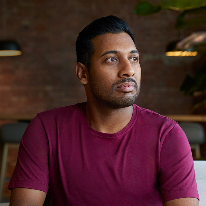 Amar istuu sisätiloissa ja katsoo vasemmalle.