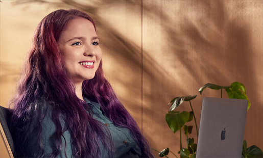 Alexa istuu ja työskentelee kannettavalla tietokoneellaan.