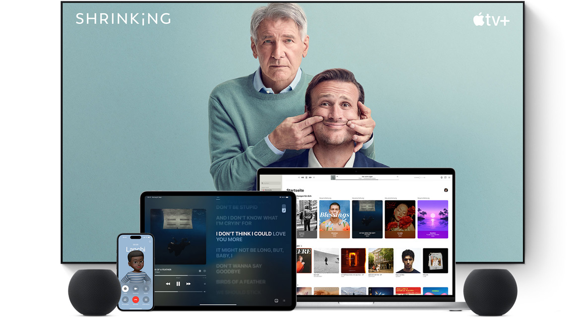 Large flat screen television showing two male characters from the Apple TV+ series shrinking. A MacBook Pro, an iPad, an iPhone, and a Midnight HomePod mini are arranged in front.
