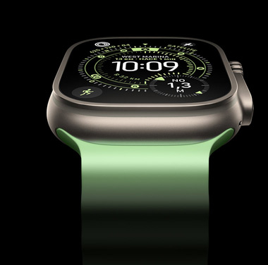 Un primer plano de un Apple Watch Ultra 3 con caja de titanio natural sobre un fondo negro. La pantalla muestra la hora y otros datos dinámicos.