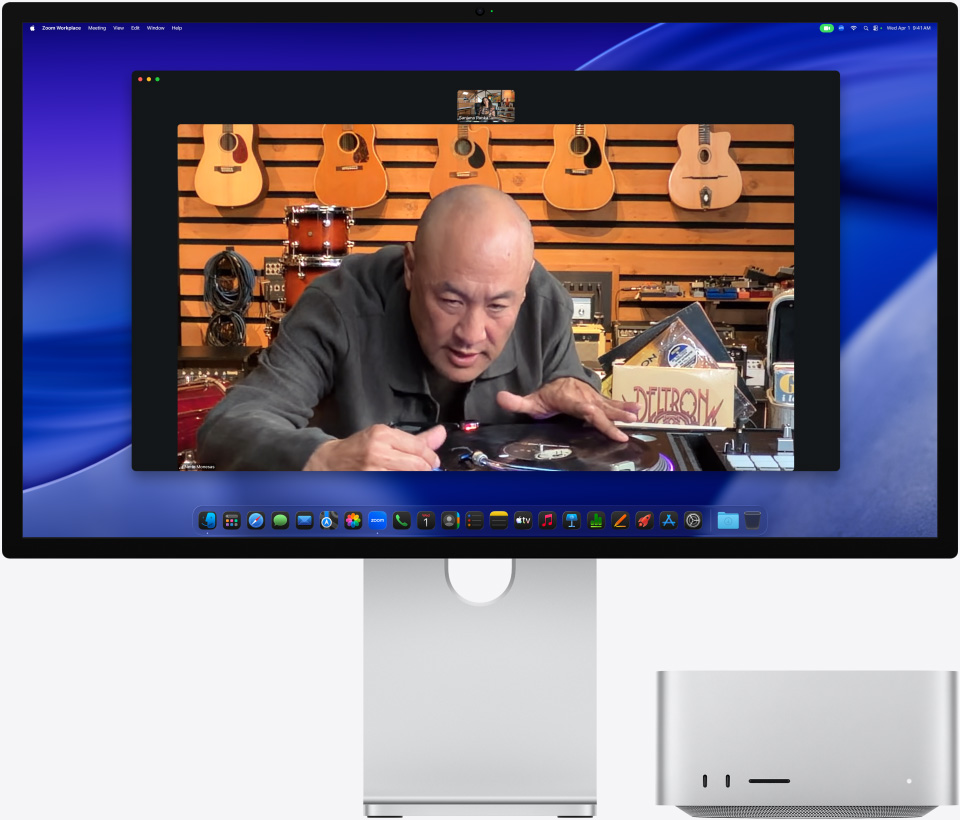 Κατά τη διάρκεια βιντεοκλήσης στο Studio Display XDR, με το Mac Studio τοποθετημένο από κάτω, ένα άτομο σε κατάστημα μουσικής εξετάζει προσεκτικά ένα πικάπ