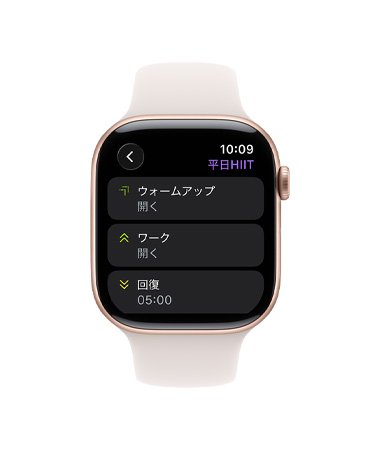 ローズゴールドアルミニウムケースのApple Watch Series 11。ワークアウトアプリとカスタムワークアウトのカードが表示され、ライトブラッシュのスポーツバンドが取りつけられている