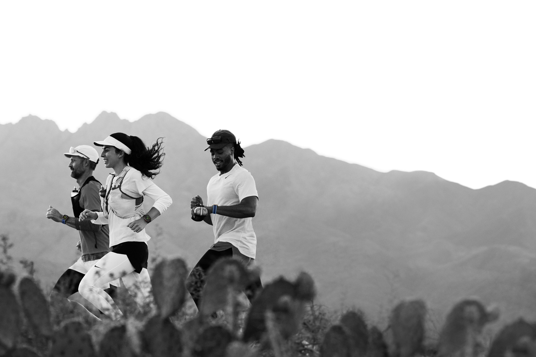 사막 트레일을 달리는 러너들이 Apple Watch Ultra 3에서 운동을 기록하는 모습