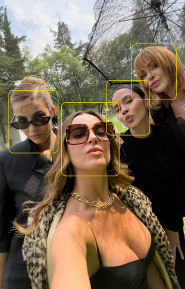 Mariana Torres tomando una selfie grupal con compañeras de reparto mientras la cámara detecta automáticamente los rostros.