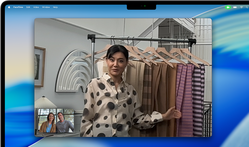 Un apel video pe un MacBook Pro, unde o femeie arată materiale textile către două persoane aflate în apel, cu Scena centrală care o menține centrată în cadru în timp ce ea se mișcă