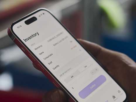 Elde tutulan bir iPhone’un yakın çekim fotoğrafı. Ekranda envanter takibi gösteriliyor.