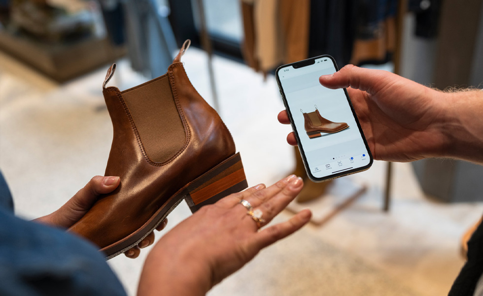 Bir çalışan NewStore iOS uygulamasını kullanarak stokları kontrol ediyor.