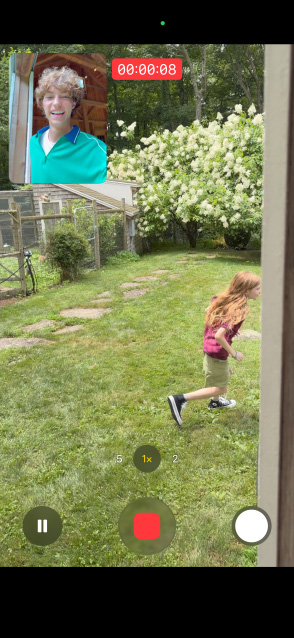 Pantalla del iPhone 17 que usa la Captura Dual para grabar en simultáneo con la cámara delantera y trasera a una chica corriendo y a un chico mirando