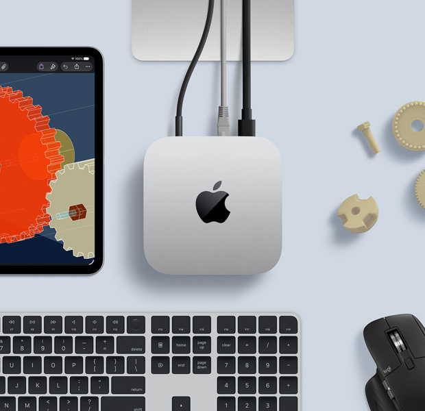 iPad displaying detailed STEM objects, Mac mini central with power cable attached, Studio Display stand partially visible, connected via USB-C, Magic Keyboard with Touch ID, and Logitech mouse