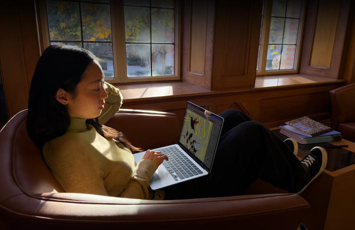 Una persona seduta su una sedia che usa un MacBook Air