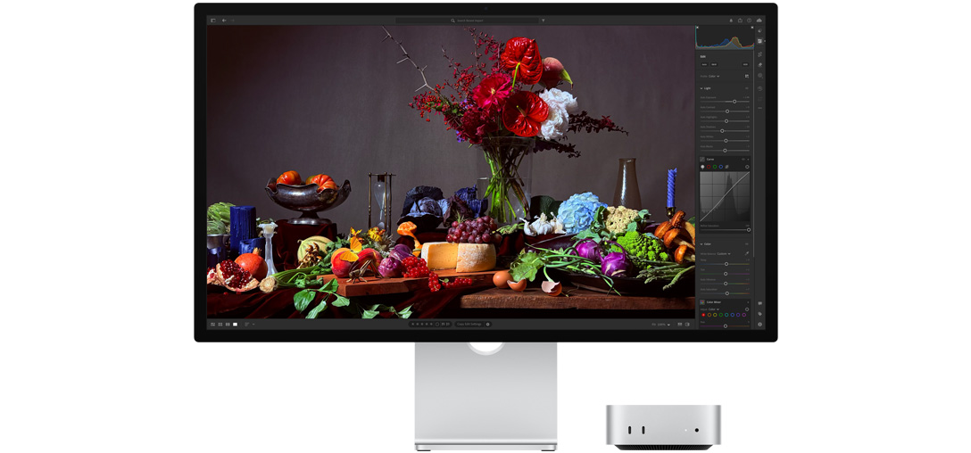 Une image très contrastée d’une table sur laquelle sont posées plusieurs assiettes remplies et un bouquet sur fond sombre, montrant l’ajustement de la tonalité générale avec True tone.